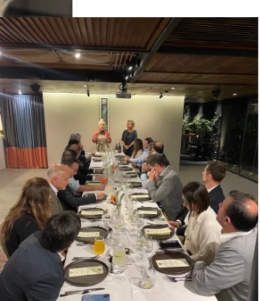 Registro de encuentro corporativo con asistentes reunidos alrededor de una mesa